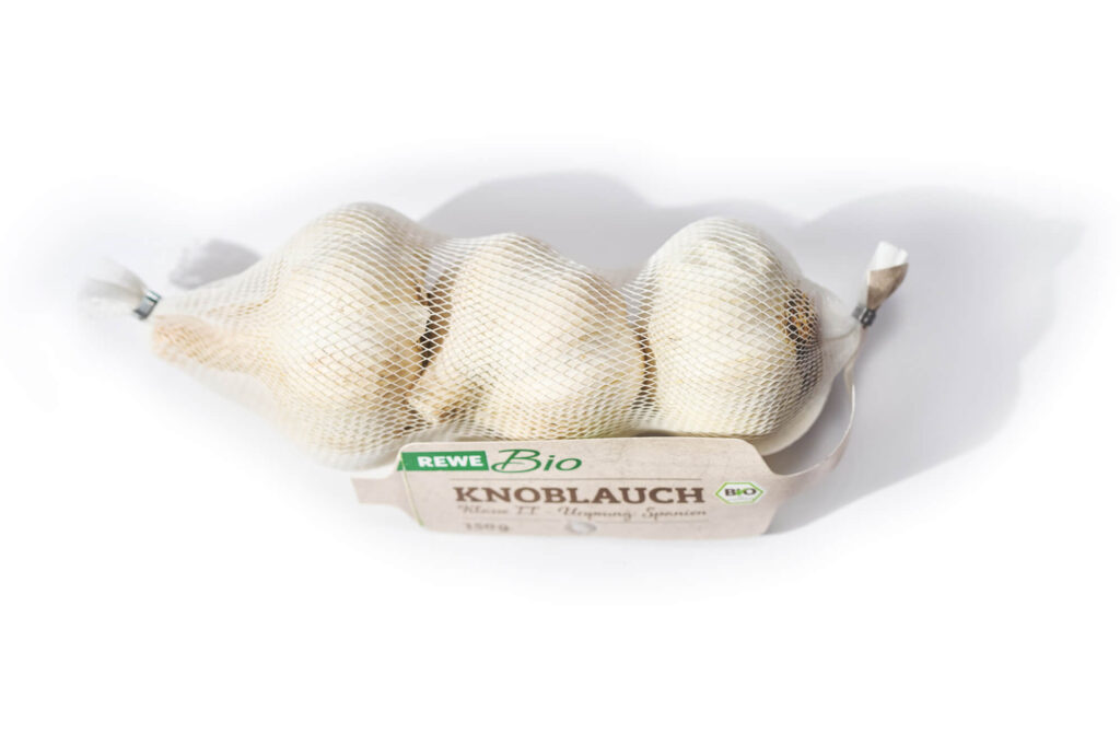 Bio-Knoblauch in weißem Solipac Schlauchnetz mit ökologischem Stegetikett – atmungsaktive Verpackung für Gemüse.