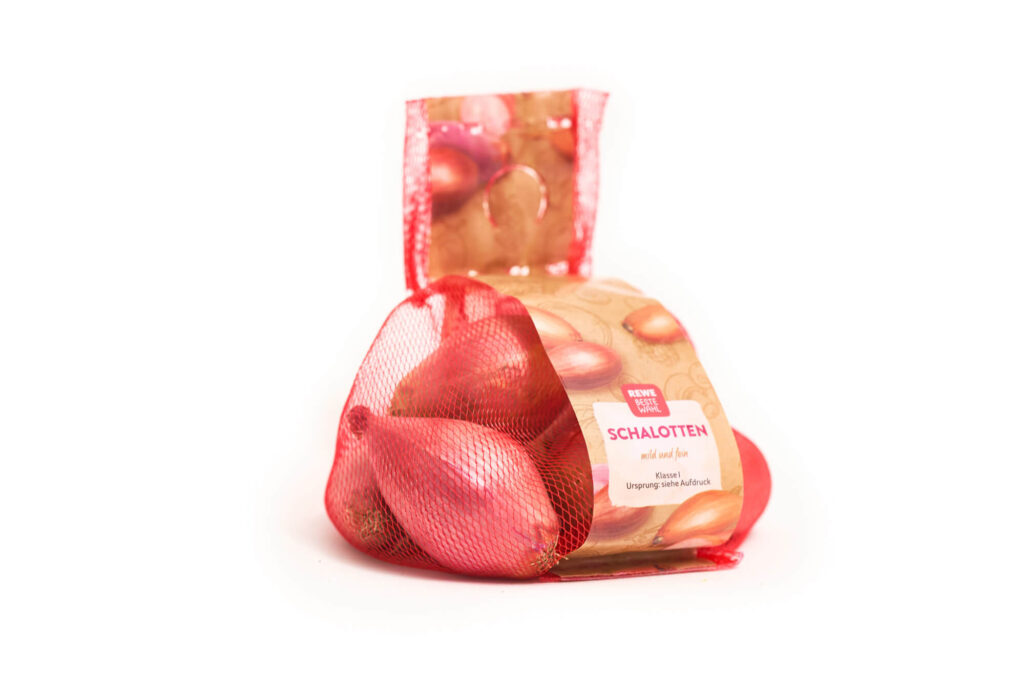 Schalotten in rotem Solipac Raschelsack mit Banderole – atmungsaktive Netzverpackung für frisches Gemüse im Einzelhandel.